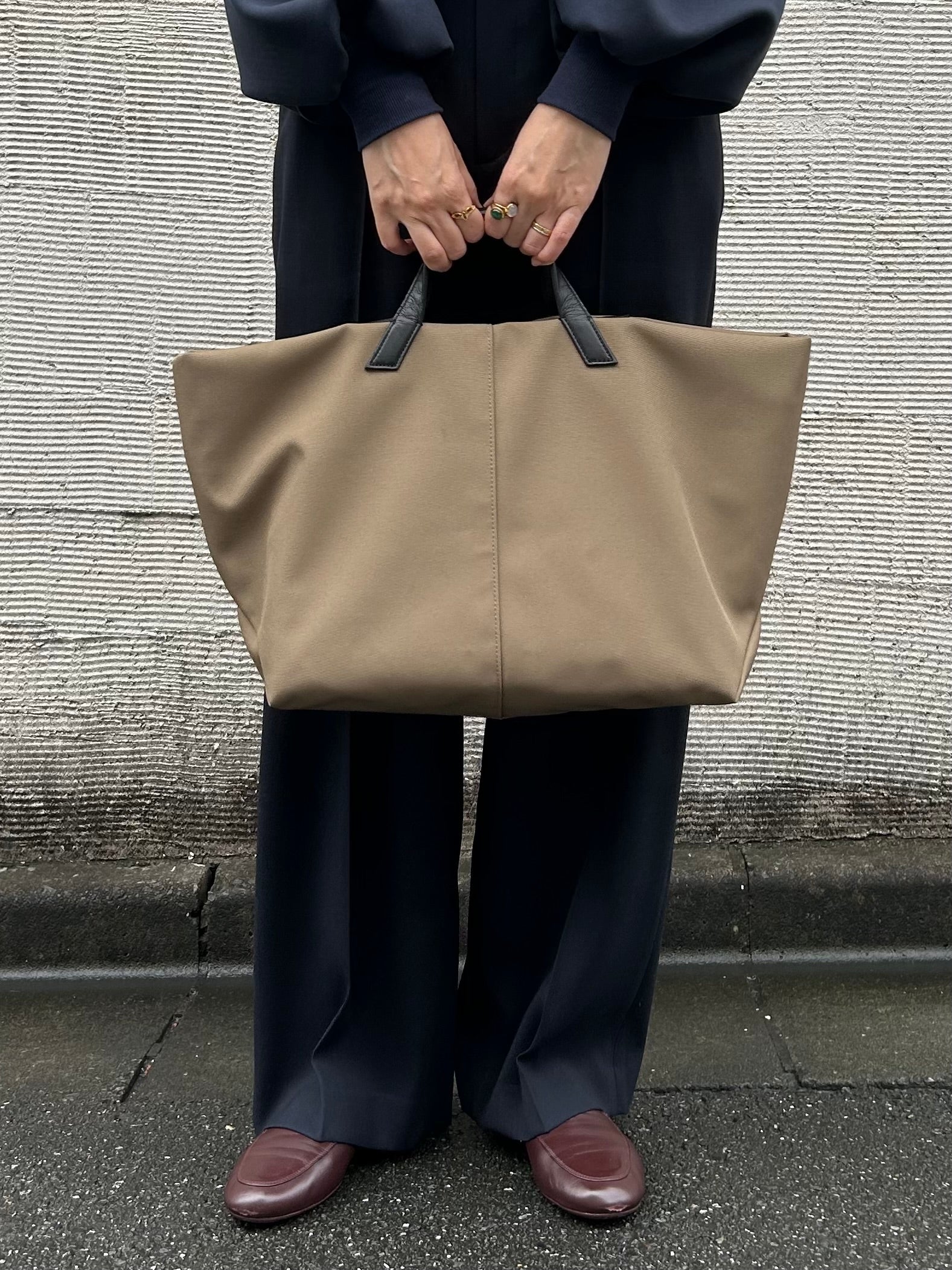 シャツとニット、デニムにブラックのaibōを手持ちしたコーディネート